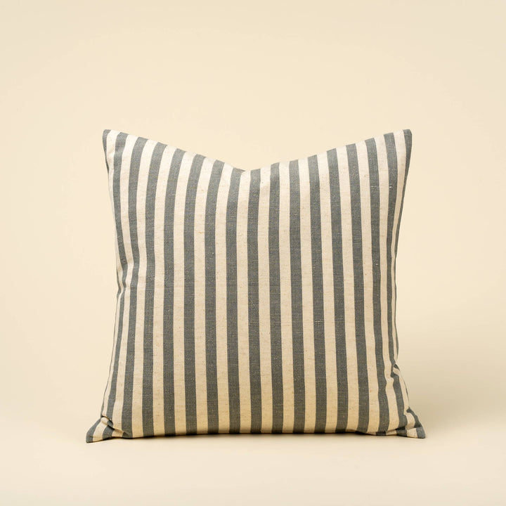 Striped pillow with blue and beige pattern on a beige background