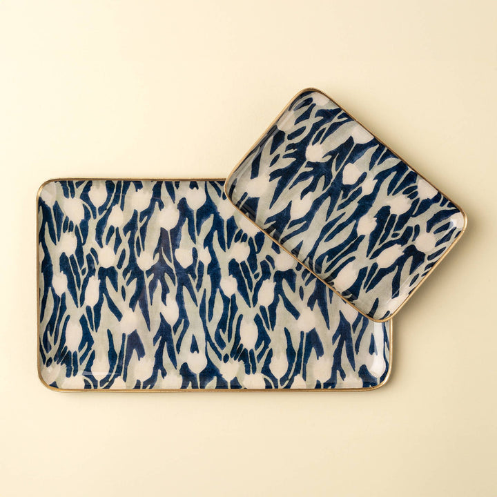 Two ceramic trays with blue and white abstract flower pattern on a beige background