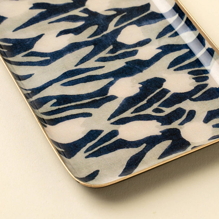 Decorative tray with blue and white abstract tulip pattern on a beige background