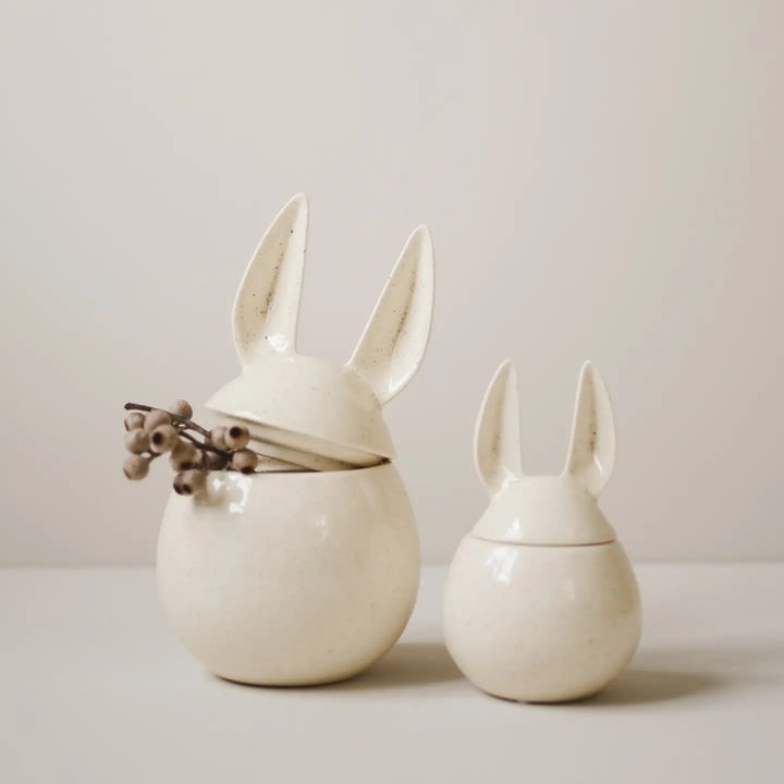 Two ceramic rabbit-shaped containers on a light background