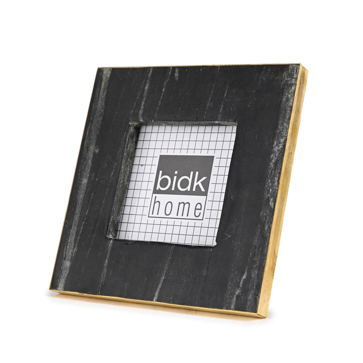Black marble photo frame with gold trim on a white background