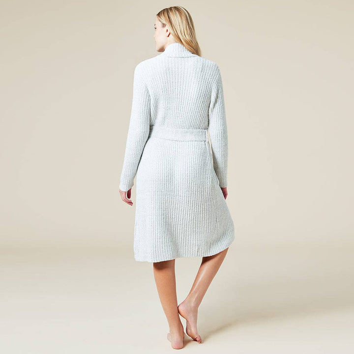 Woman wearing a light gray ribbed knit robe against a beige background