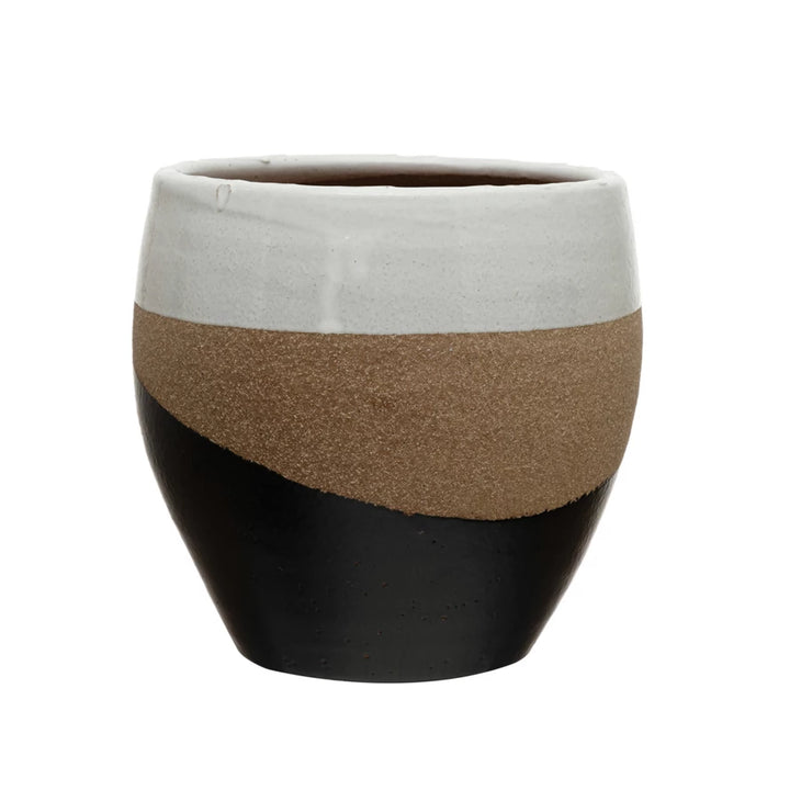 Multicolored planter with black, brown, and white segments on a white background