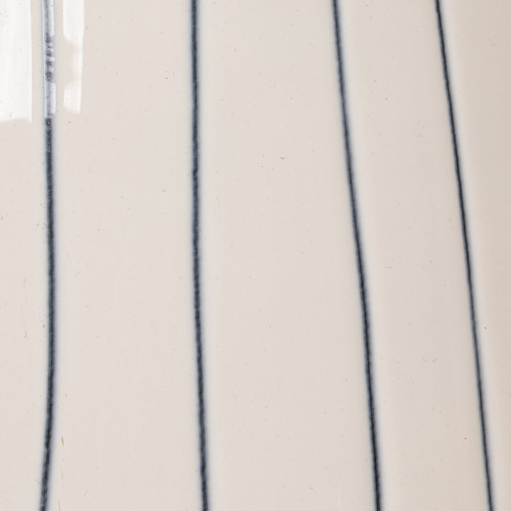 White ceramic watering can with blue stripes