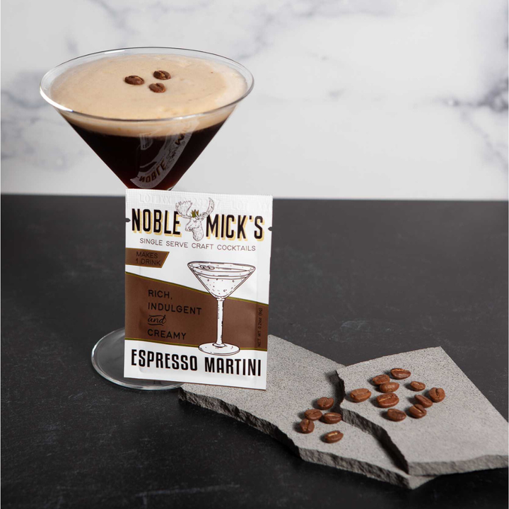 Noble Mick's Espresso Martini cocktail with a glass and packaging on a dark surface.