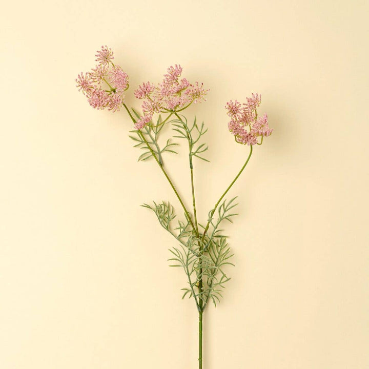 Pink flowers on green stems against a beige background