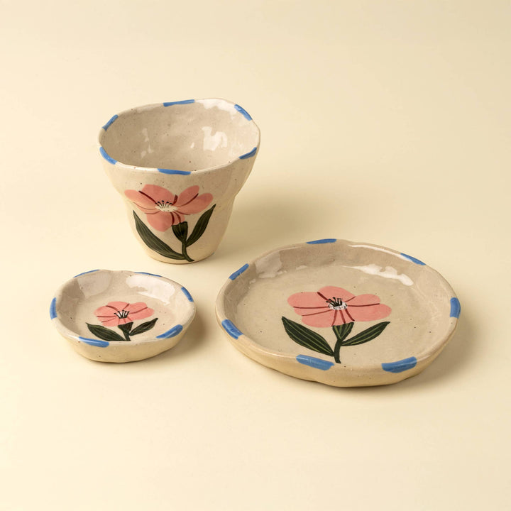 beige ceramic plate with a pink flower design and blue accents