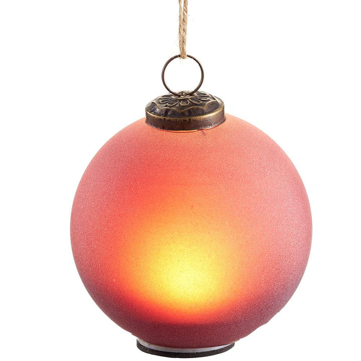 A red blown glass ornament with a battery operated light feature with flat bottom