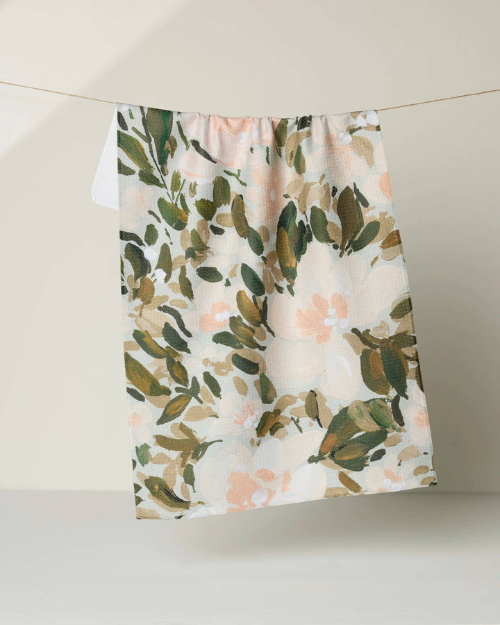 Floral patterned geometry towel hanging on a line against a neutral background