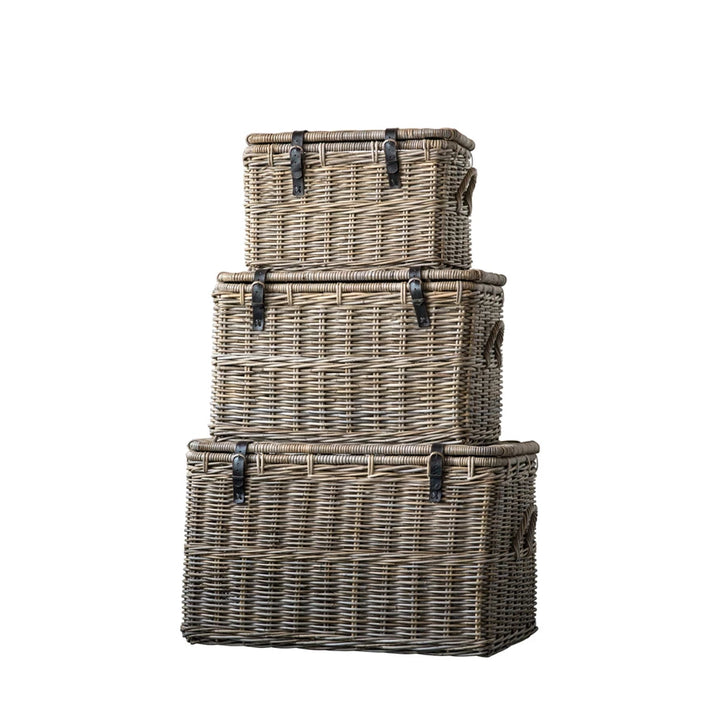 Set of three woven baskets stacked on a white background