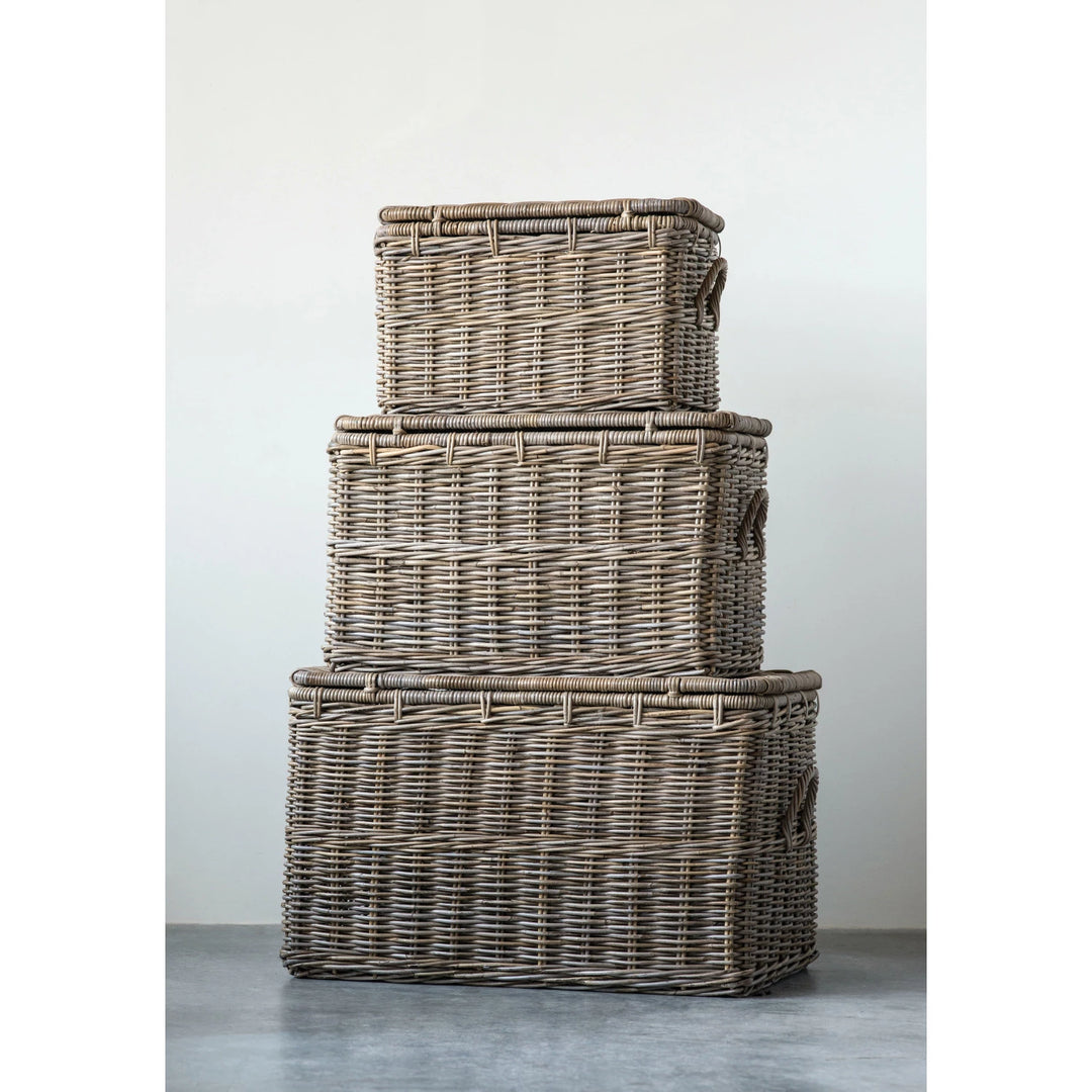 Stack of three wicker baskets on a gray surface with a white background