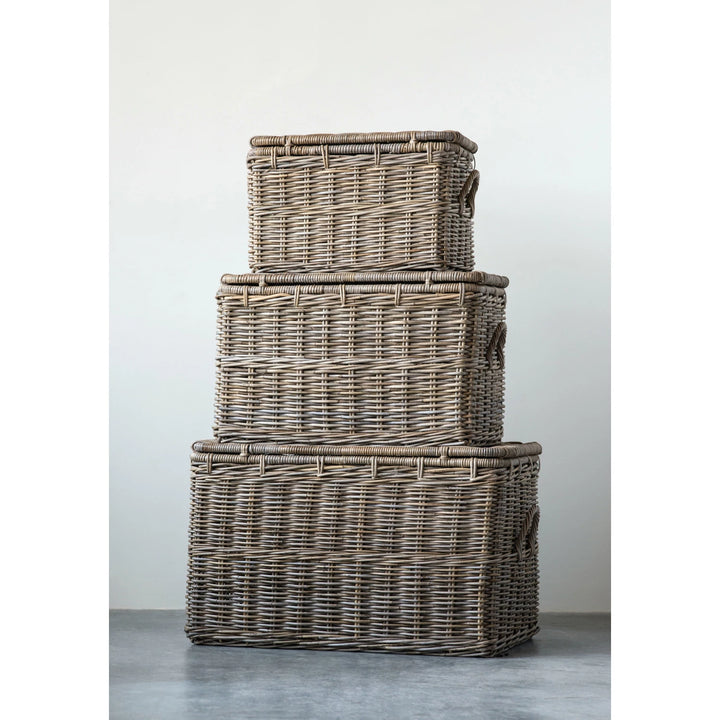 Stack of three wicker baskets on a gray surface with a white background