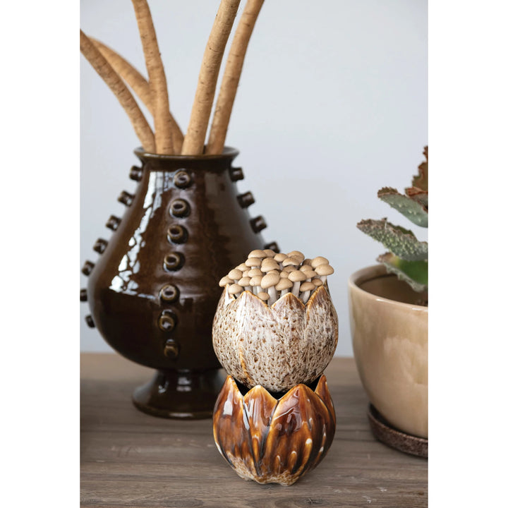 Decorative ceramic pots with natural elements on a wooden surface
