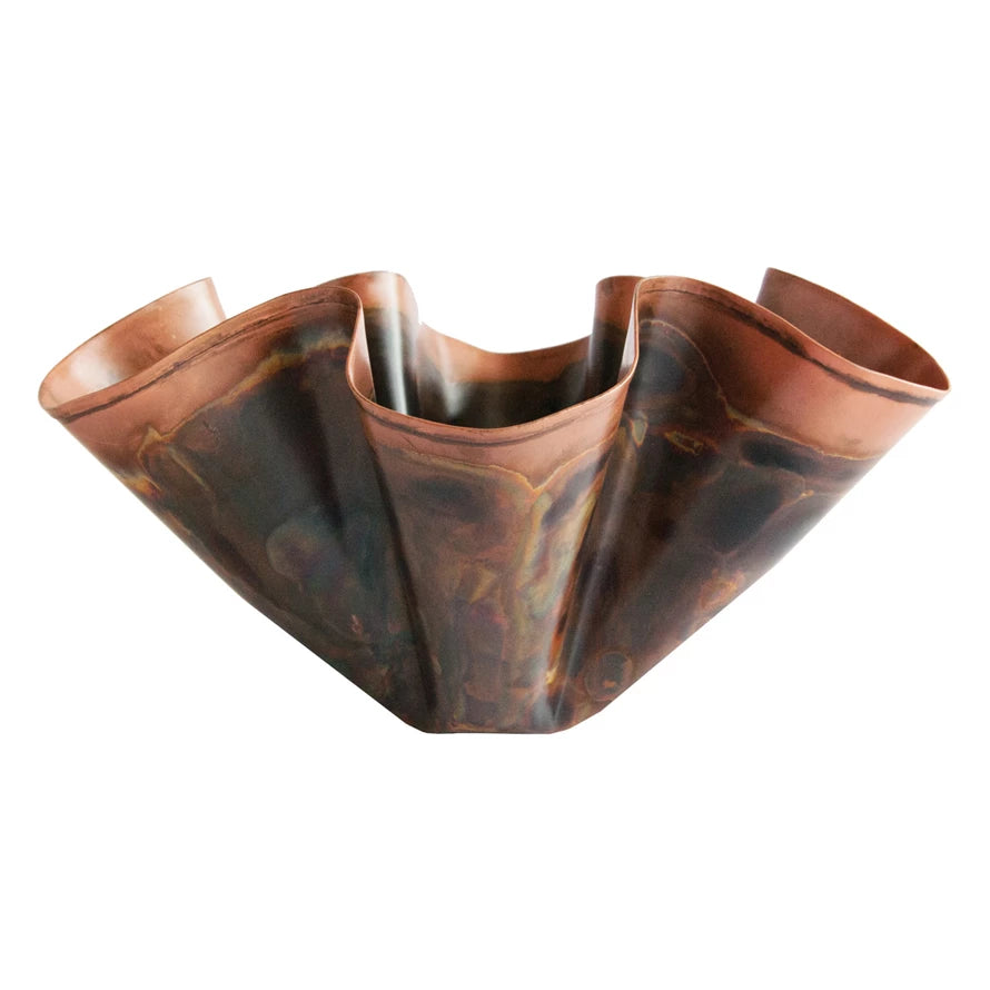Copper bowl with wavy design on a white background