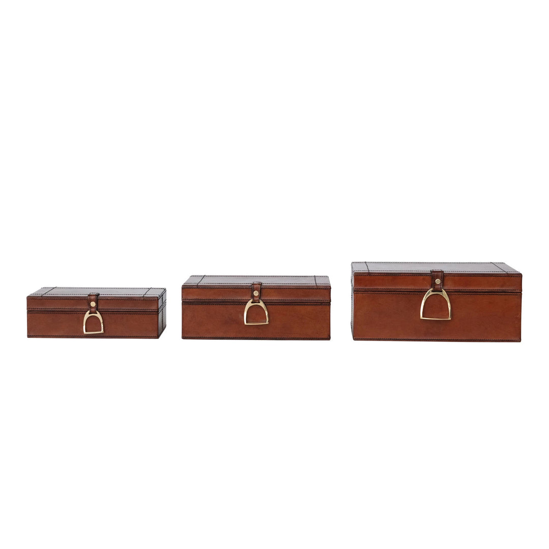Three brown leather boxes with gold handles on a white background