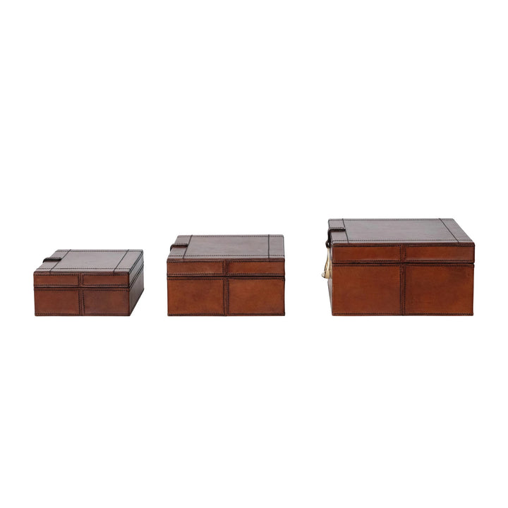 Set of three brown leather boxes with different sizes on a white background