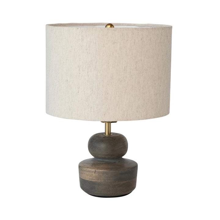 Table lamp with a textured beige shade and wooden base on a white background