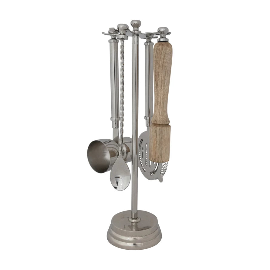 Set of kitchen utensils including a jigger, spoon, and strainer, muddler on a stand with a wooden handle.