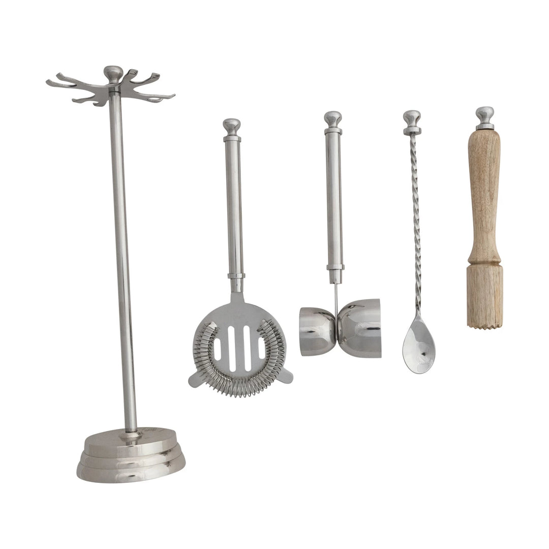 Set of bar tools including a jigger, strainer, and other utensils on a white background