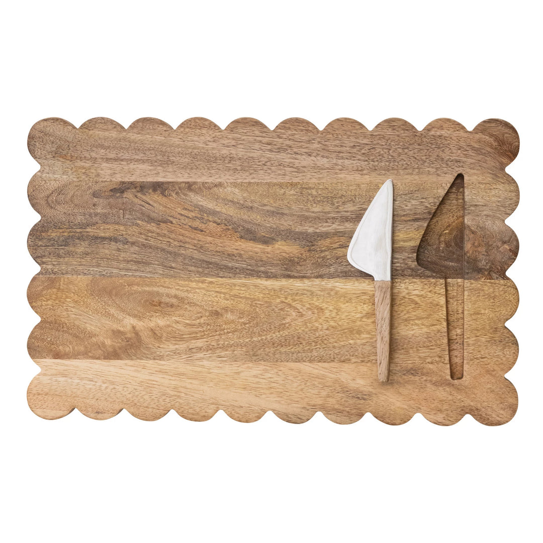 Wooden cutting board with scalloped edge and a knife 