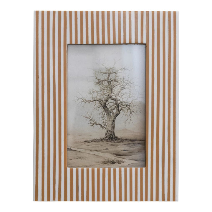 white and caramel color striped frame with a picture of a dead tree