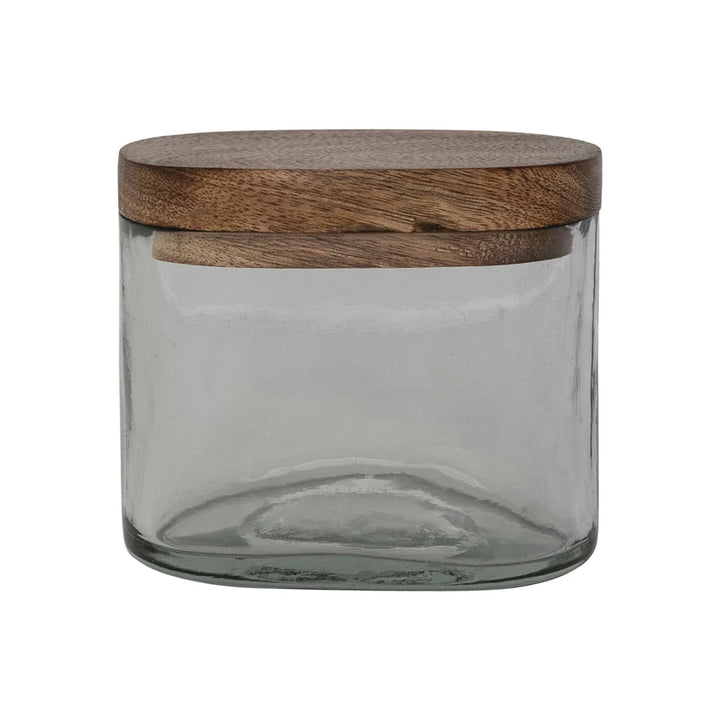 Clear glass jar with a wooden lid on a white background