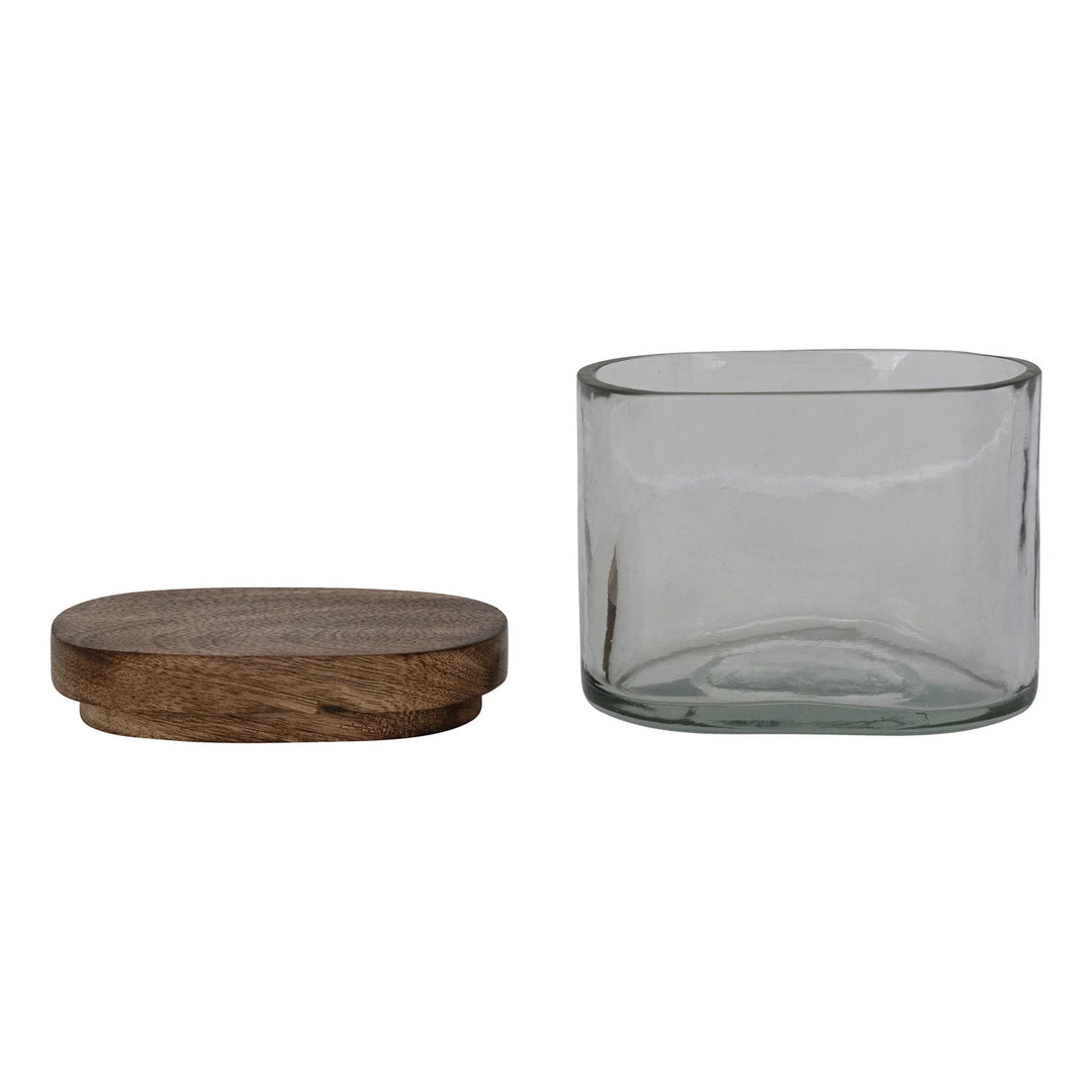 Clear glass canister with wooden lid on a white background