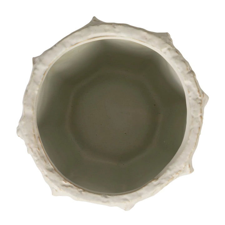 Ceramic bowl with textured rim on a white background