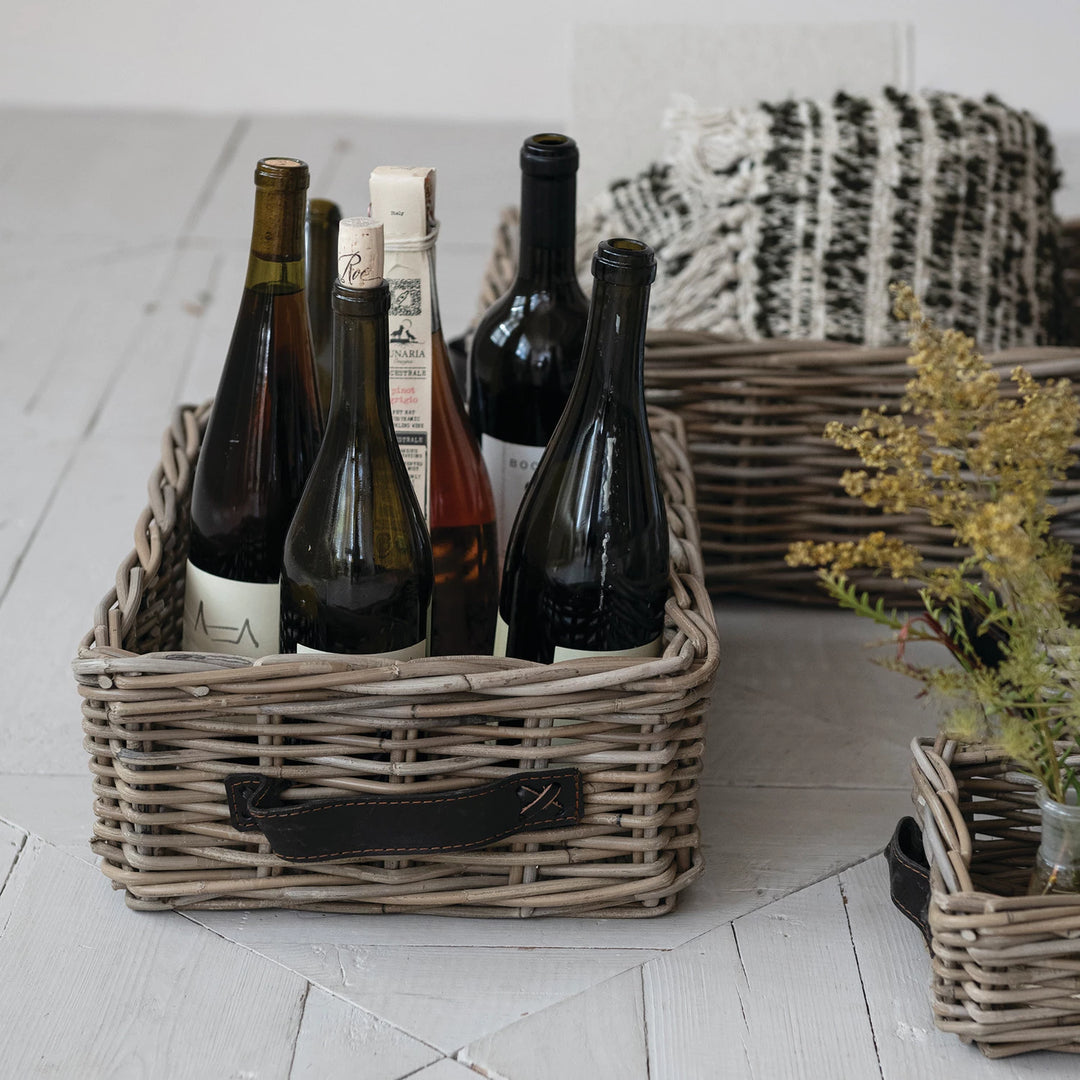 Wicker basket with wine bottles on a light wooden floor