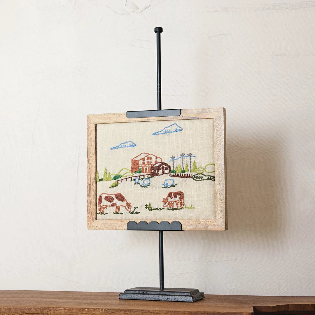 black metal scalloped edge easel holding embroidered photo