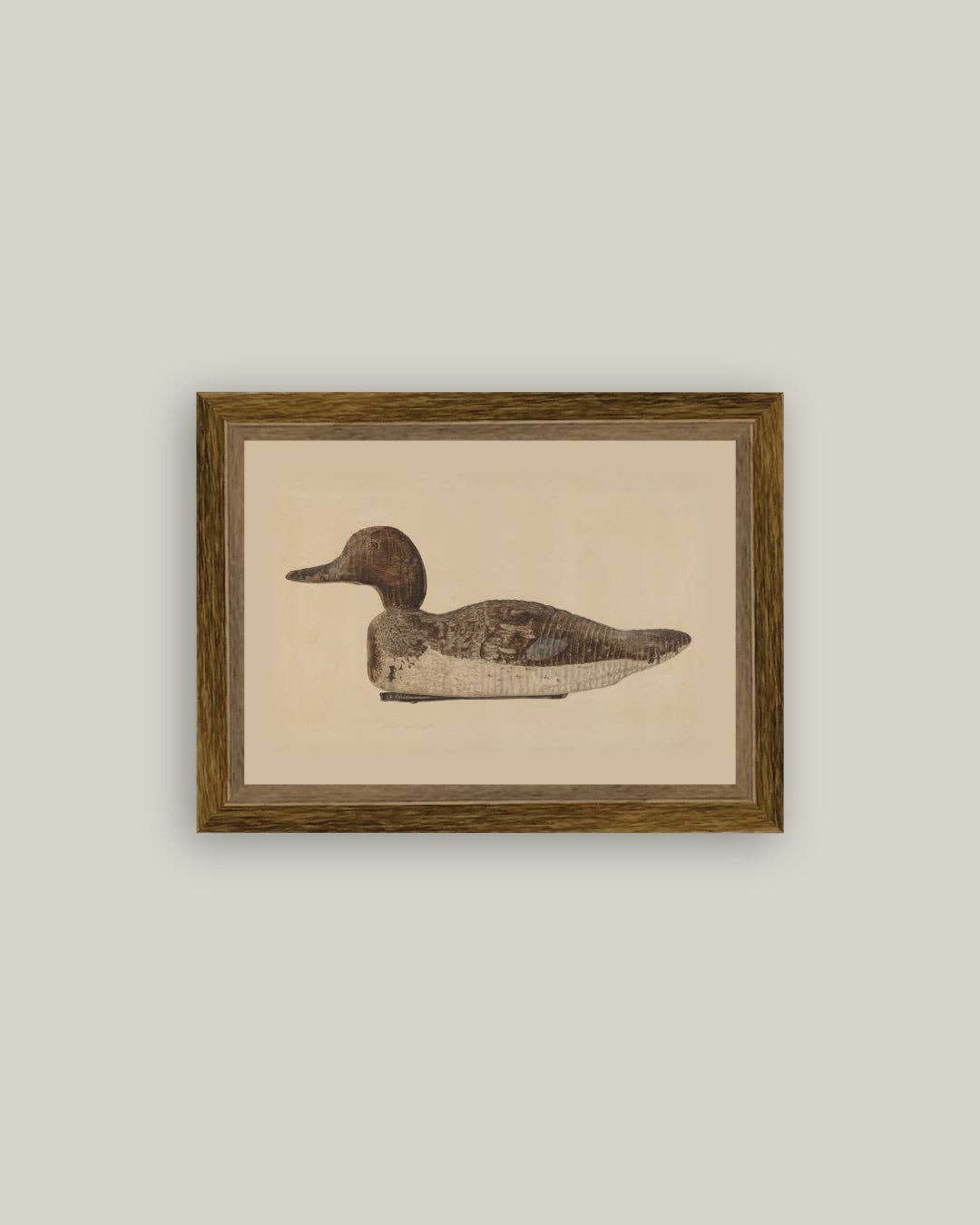 Framed artwork of a duck decoy with a beige background
