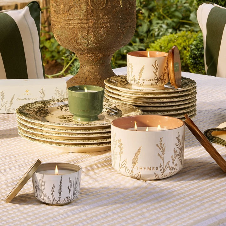 citronella Candles with 'Thyme' branding on a table outdoors