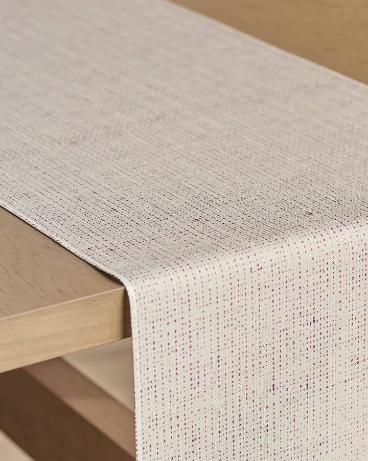 Textured beige table runner on a wooden table