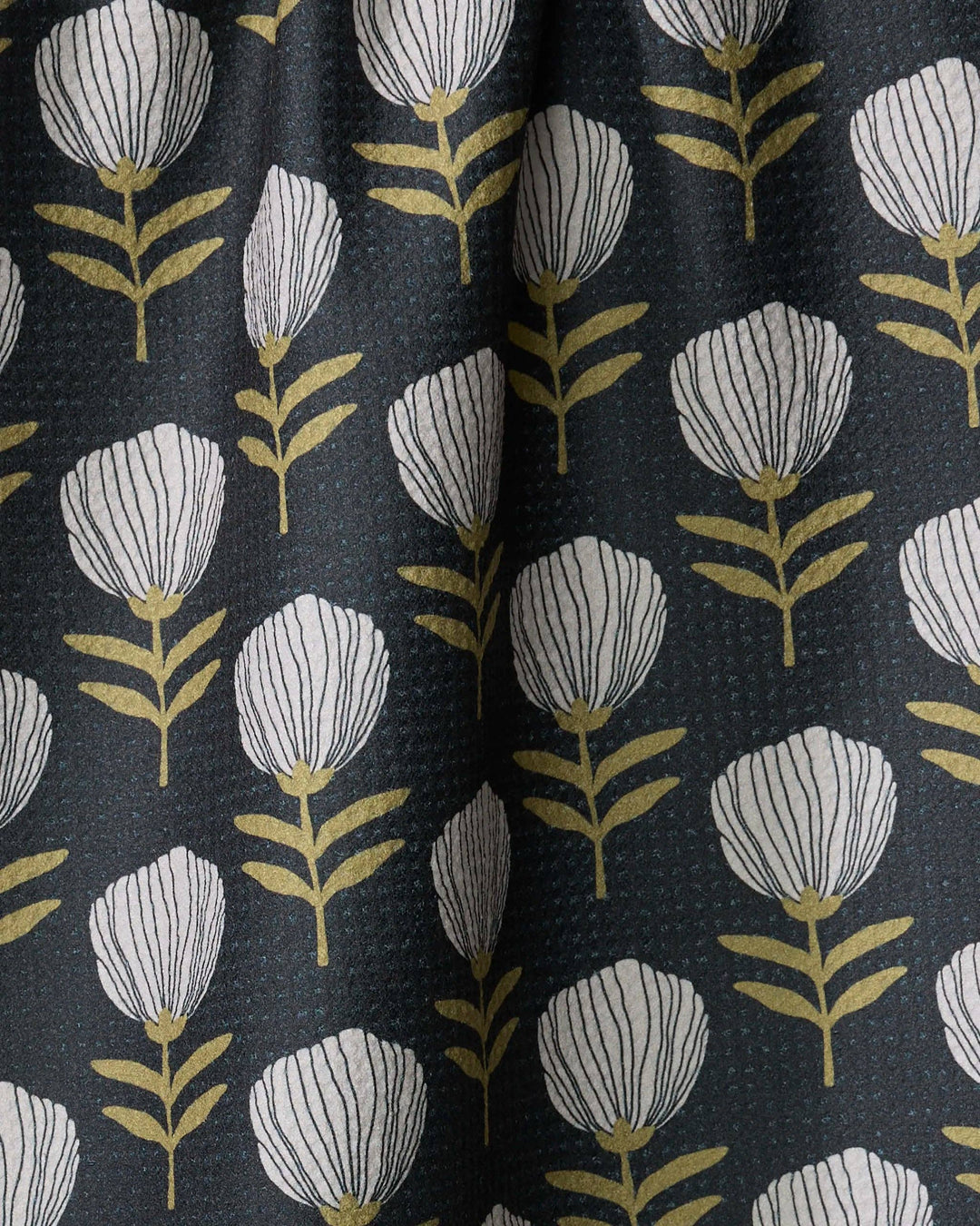 Geometry towel with a floral pattern featuring white flowers and green leaves on a dark background