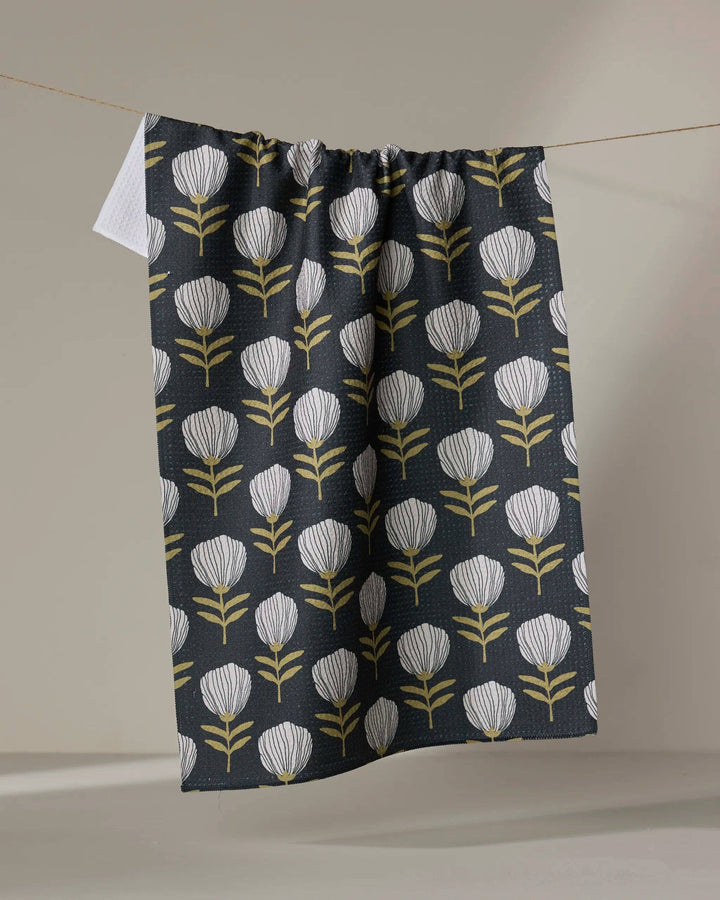 Floral patterned towel hanging on a line against a neutral background