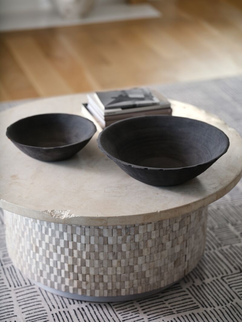 Two handcrafted terracotta bowls with matte black finish, one large and one small, displayed side by side.