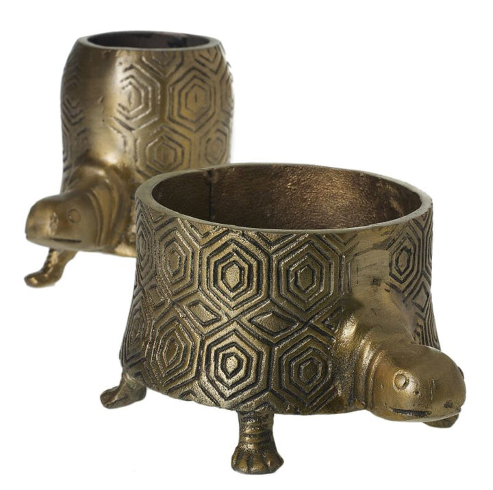 Two bronze turtle-shaped candle holders on a white background
