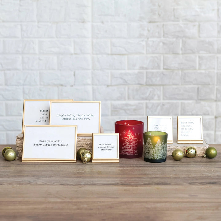 gold finish metal and glass frames with easels and Christmas-themed sayings written in them.