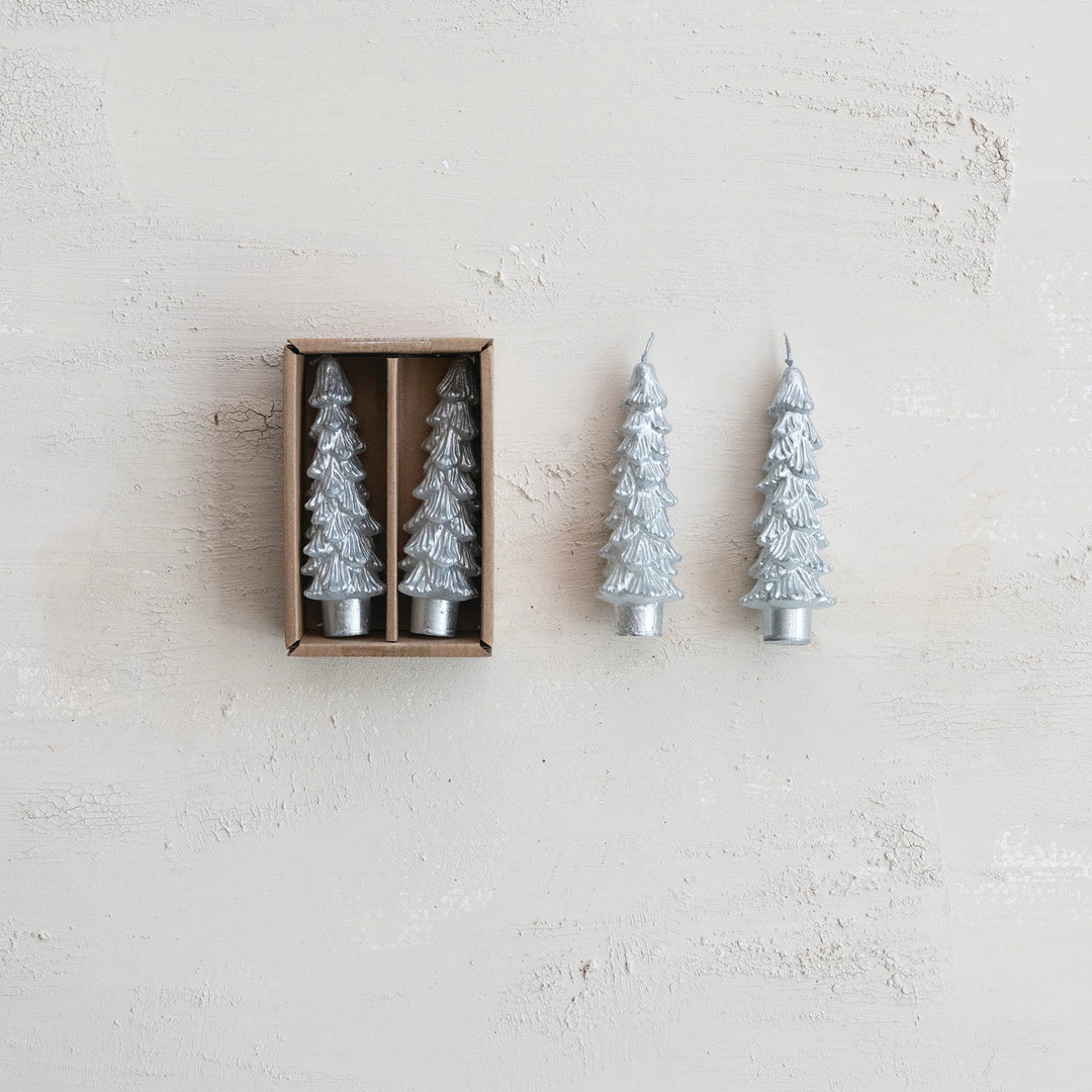 A set of two silver tree-shaped taper candles displayed next to their packaging