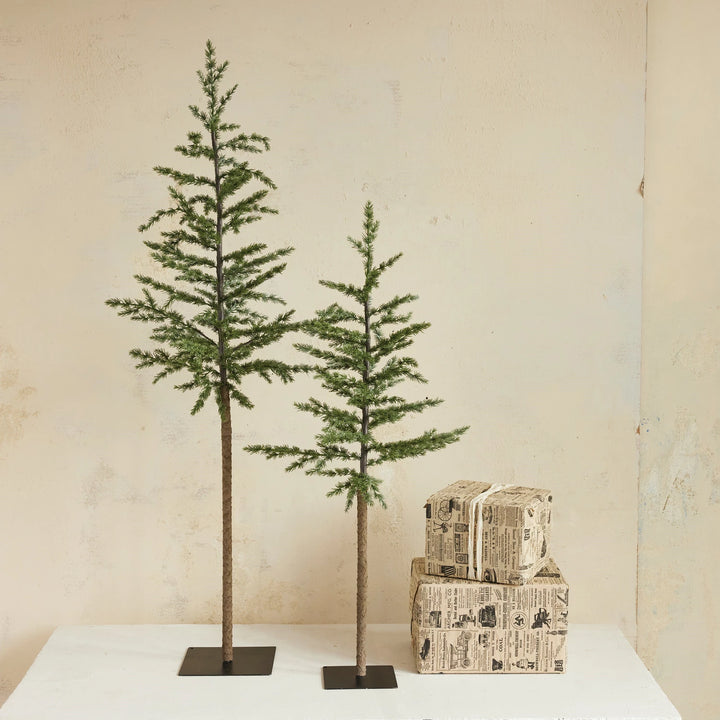 Two faux pine trees with metal bases  one larger one smaller